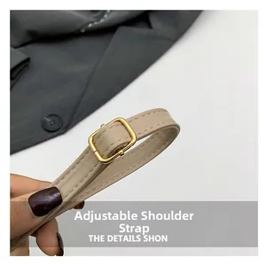 Détail d'une bandoulière réglable en similicuir beige avec boucle en métal doré
