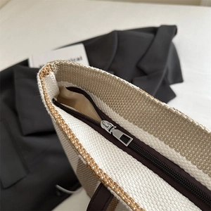 Close-up of metal zipper closure and inner lining of striped canvas tote bag