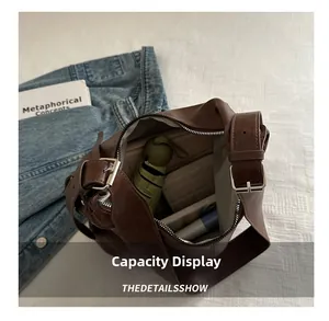 Spacious interior of dark brown vintage shoulder bag holding umbrella and wallet