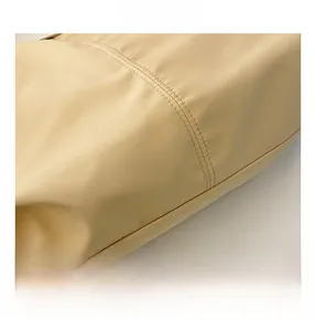 Close-up of beige canvas fabric texture with precise double-needle stitching on tote bag