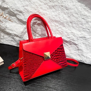 Elegant red handbag with gold pyramid lock and exotic textured panels for women