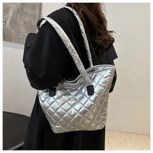 Silver quilted tote bag with metallic finish shown on model for daily commuting