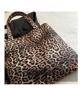 Détails du sac cabas chic à imprimé léopard posé sur un arrière-plan en tissu texturé