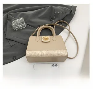 Vue détaillée du sac beige avec fermoir fleuri doré et base à texture crocodile