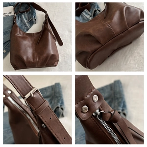 Detail view of deep brown hobo bag showing pleats, buckle strap and zipper hardware