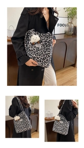 Detail of leopard print canvas tote bag featuring a plush white cloud charm on the strap