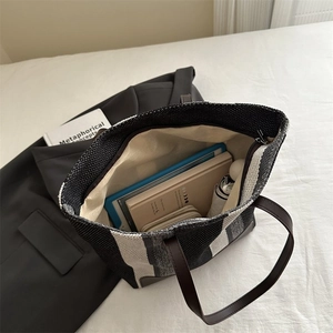 Detail view showing large capacity interior with striped woven texture and brown straps