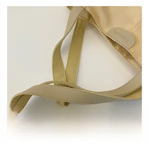 Detail view of cream tote bag showing durable shoulder straps and FASHION embossed leather trim