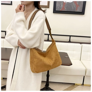 Gros plan d'un grand sac cabas vintage en daim jaune gingembre avec bandoulière en cuir
