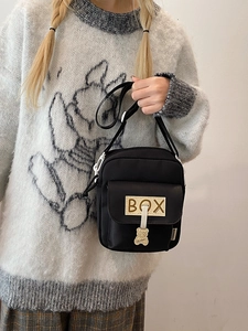 Cute Japanese style black nylon crossbody bag with bear pendant shown on model