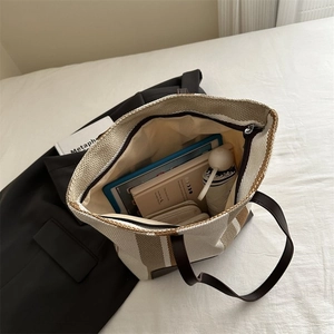 Close-up of the spacious interior of a striped canvas tote bag with a zipper closure