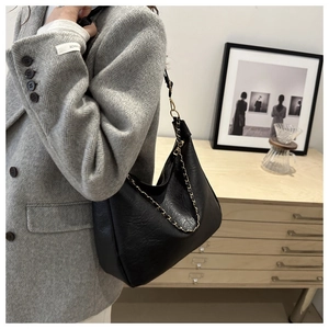 Détail d'un sac hobo en cuir noir avec une chaîne dorée élégante et raffinée