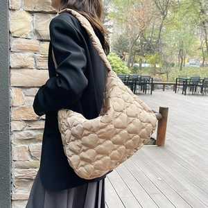 Large capacity heart quilted tote bag in beige shown on model for casual outdoor wear