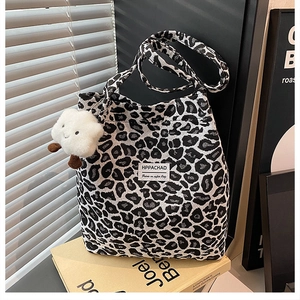 Macro detail of leopard print tote bag fabric with white label and cute plush cloud charm