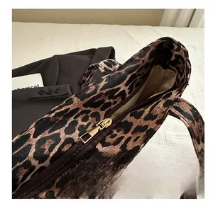 Détail d'un sac cabas à imprimé léopard avec fermeture éclair dorée et polie