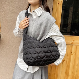 Large black quilted tote bag with heart pattern and puffy texture for women