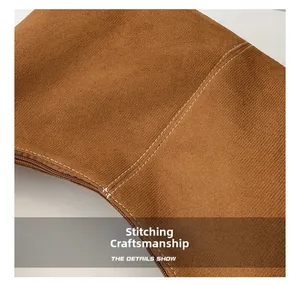 Détail de la couture blanche et de la fermeture éclair sur le sac en daim marron