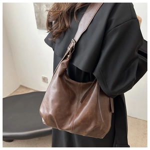 Brown soft leather tote bag showing a side view of its large capacity and strap detail