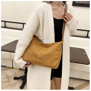 Détail du sac cabas en daim jaune montrant la texture et les coutures sur un mannequin