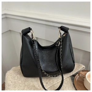 Détail du sac cabas noir en cuir à texture litchi avec chaîne dorée et bandoulière