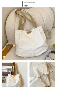 Detail view of large cream tote bag with stylish khaki shoulder straps and fashion logo