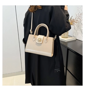 Détail du sac cabas beige avec fermoir fleuri doré élégant et texture crocodile