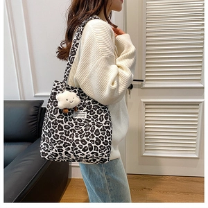 Detail of the black and white leopard print tote bag with a white plush cloud charm