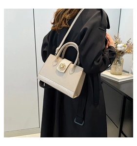 Vue détaillée arrière d'un sac cabas beige avec texture croco et fermoir fleur dorée