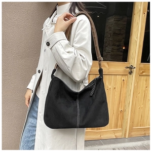 Détail du sac Hobo noir avec surpiqûres blanches et bandoulière en cuir marron