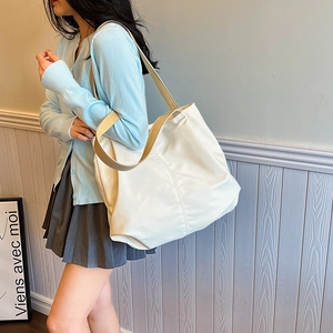 Detailed view of cream white large capacity tote bag with brown fabric shoulder strap