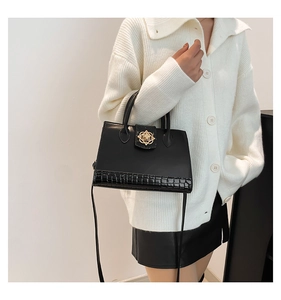 Détail du sac cabas noir avec cuir effet croco et boucle florale dorée