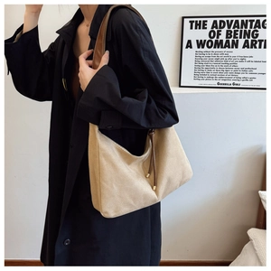 Détail du sac cabas beige minimaliste avec anses marron et accents de cordon en métal