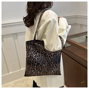 Sac fourre-tout à imprimé léopard porté avec un blazer blanc pour un look chic