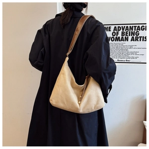 Vue de dos d'un modèle portant un grand sac cabas beige mat avec cordons de serrage