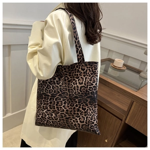 Détail d'un grand sac cabas à imprimé léopard associé à un élégant trench-coat beige classique