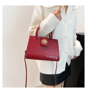 Détail du sac cabas en cuir rouge embossé croco avec fermoir fleur dorée et bandoulière