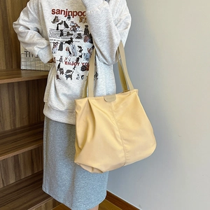 Detail of a large yellow nylon tote bag showing soft texture and Fashion logo