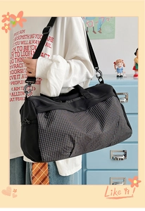 Detail view of the black and white checkered pattern and wide nylon shoulder strap