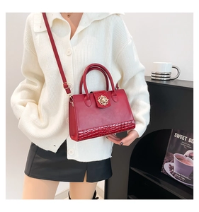 Détail du sac cabas rouge en similicuir avec texture crocodile et boucle rose dorée
