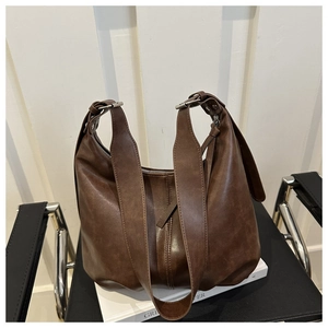 Detailed shot of the brown soft leather Hobo tote bag resting on white books