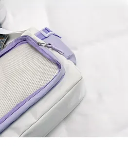 Close-up detail of the lightweight white and lilac nylon fabric and grid pocket on messenger bag