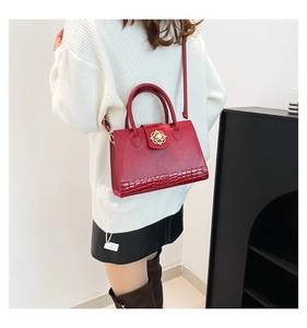 Détail du sac à main rouge avec cuir motif crocodile et fermoir floral doré chic