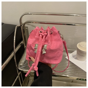 Detail of a pink drawstring bucket bag with a metallic silver bow and pleated texture