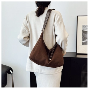 Vue détaillée du sac à bandoulière en daim marron foncé avec couture blanche et sangle