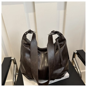 Detailed close-up of dark brown hobo bag texture with silver buckle on shoulder strap