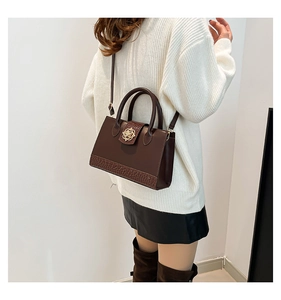 Détail du sac cabas marron foncé avec texture crocodile et fermoir floral doré
