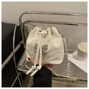 Close-up of white marble pattern bucket bag with silver metal bow and drawstring