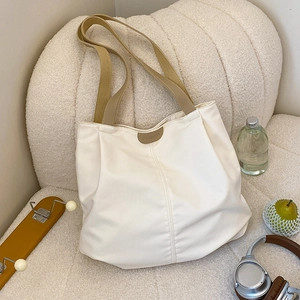 Detail of white canvas tote bag with brown PU handle and fashion leather patch decoration