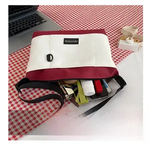Detail showing the spacious interior of the red and white canvas crossbody bag