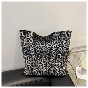 Gros plan d'un sac cabas en toile à imprimé léopard avec texture noire et blanche sur cuir